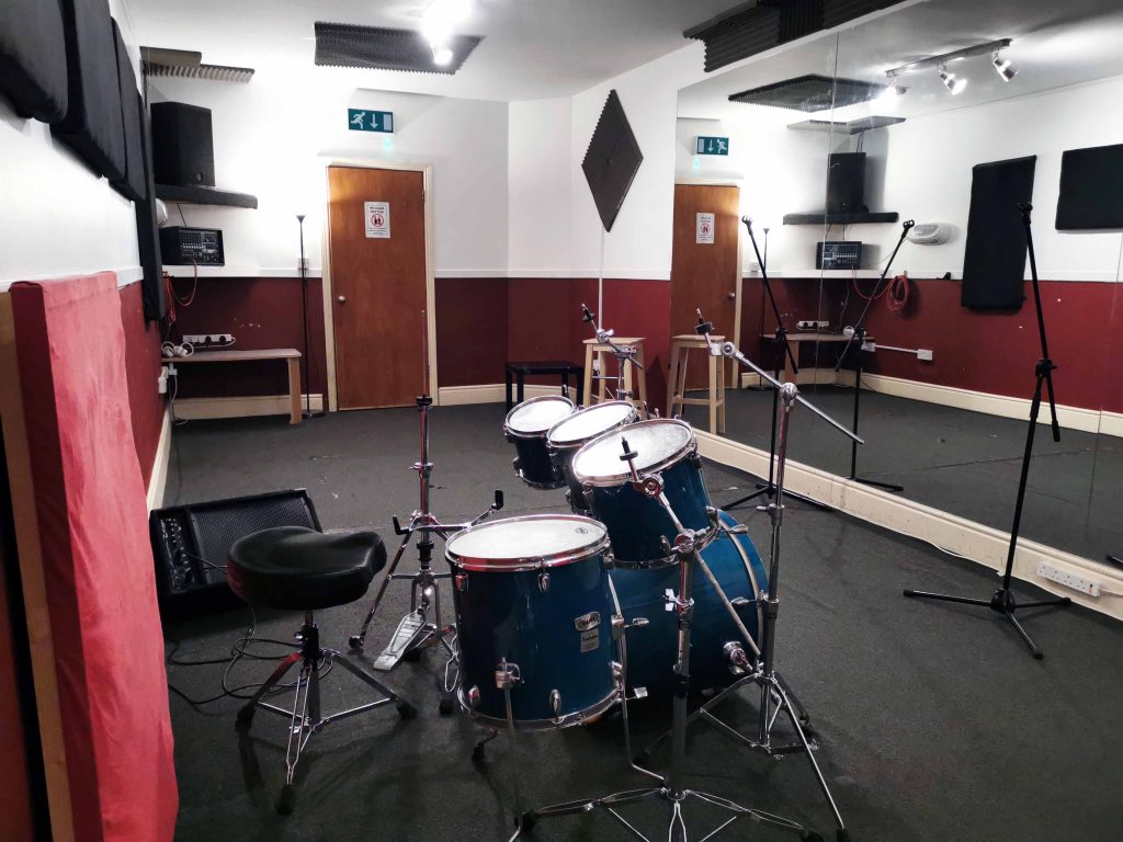Large room with carpet floor and large wall Mirrors. EV/Yamaha PA & floor monitor. Mapex Pro M fusion size kit.