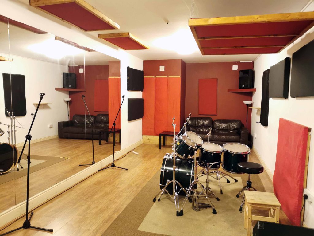 Large room with wooden floor and large wall Mirrors. EV/Yamaha PA & floor monitor. Mapex Pro M rock size kit