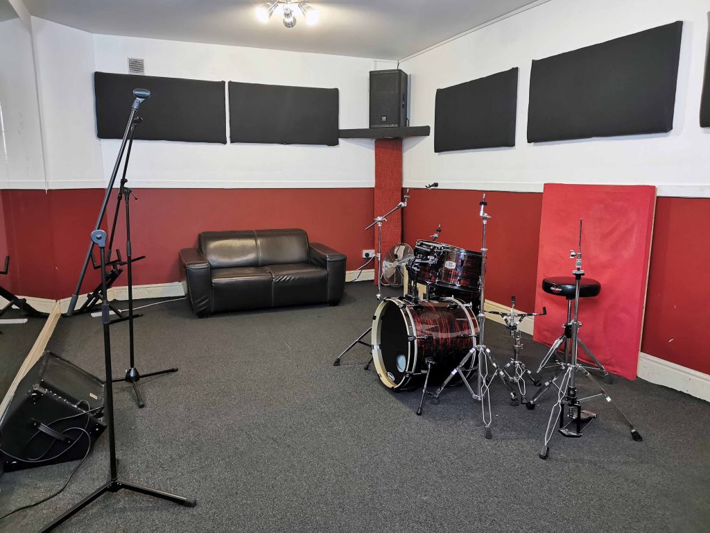 Mid size room with carpet floor, large wall Mirrors. Bose/Yamaha PA & floor monitor. Pearl EXR fusion size kit.