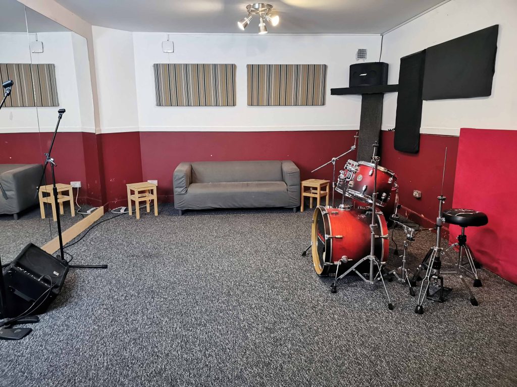Mid size room with carpet floor, Mirror. Bose/Yamaha PA & floor monitor. Sonor rock size kit.